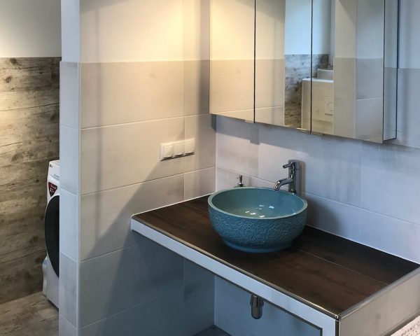 VON ANFANG AN GUT GEPLANT! türkise Waschschüssel auf einer verfliesten Waschtisch-Mauerbank, darüber ein dreitüriger Spiegelschrank