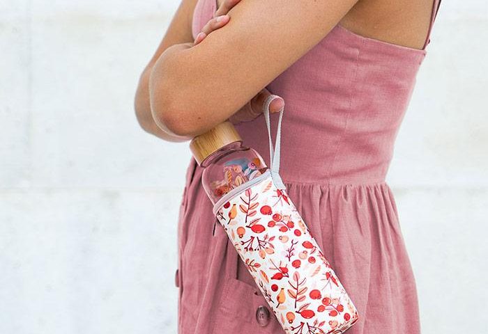 Frau lässt Waterdrop-Flasche im Thermosleeve an der Halteschlaufe baumeln 